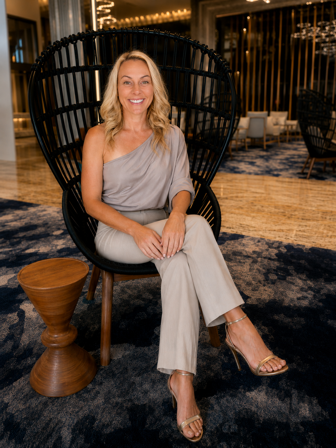 Orshi McNaughton seated in a woven chair in a Cancun lobby.